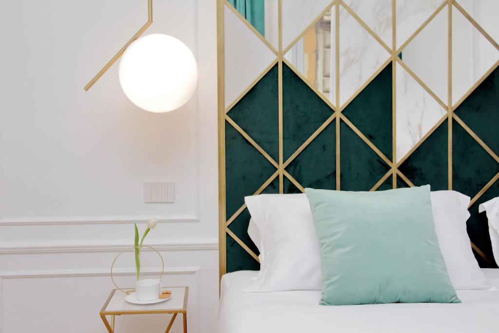 罗马Domna Luxury Suites的一间卧室配有一张带绿色床头板的床