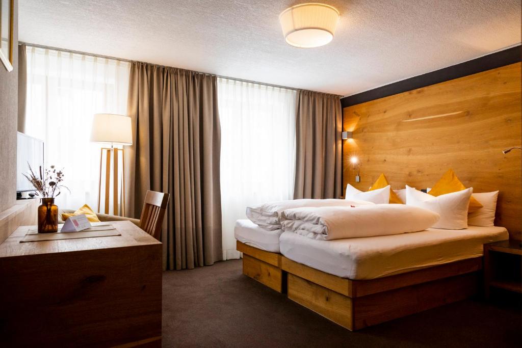 圣安东阿尔贝格蒙特福特酒店的酒店客房配有两张床和一张书桌