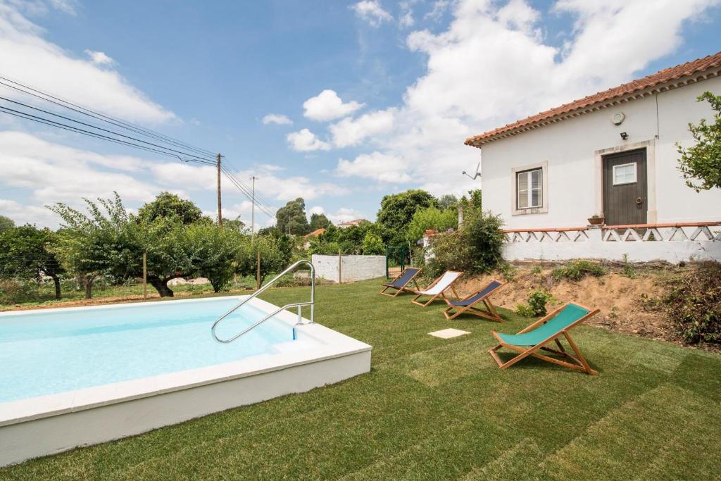 São João da RibeiraAvó Rosa Guesthouse的后院设有游泳池、椅子和房屋