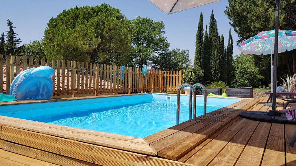 蒙托鲁Mas Orféo的一个带木甲板和遮阳伞的小型游泳池