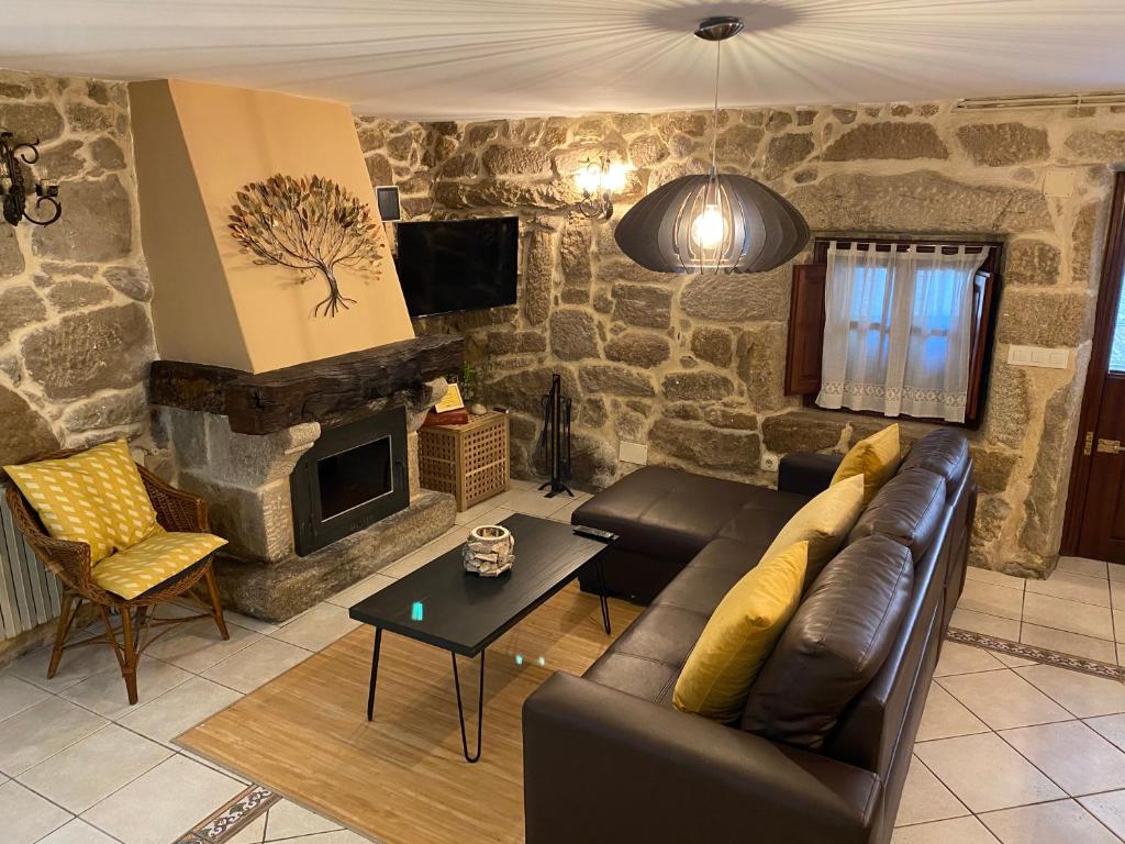科巴罗Casa Rualeira的带沙发和石制壁炉的客厅