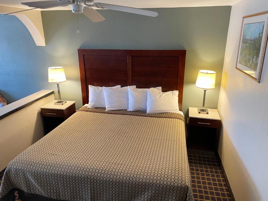 卡尔斯巴德西部大酒店及套房的酒店客房,配有一张带两盏灯的床