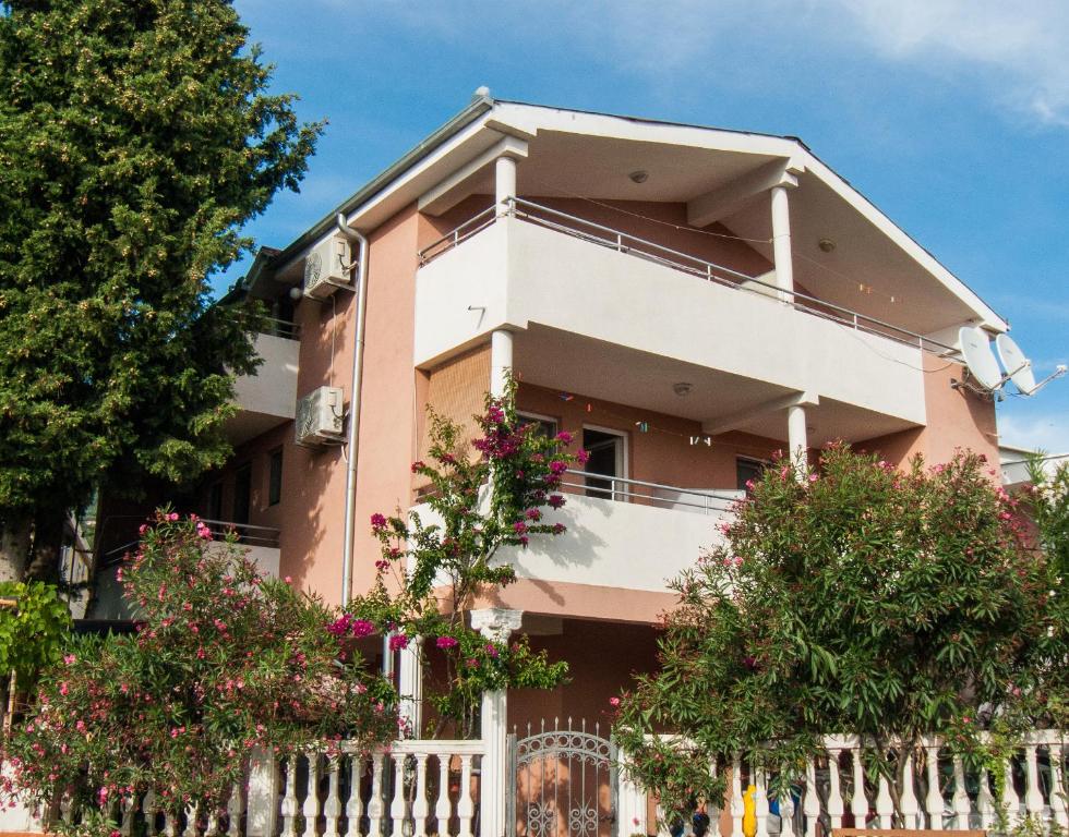 多布拉沃达Apartments Milka的粉红色的房子,有白色的围栏