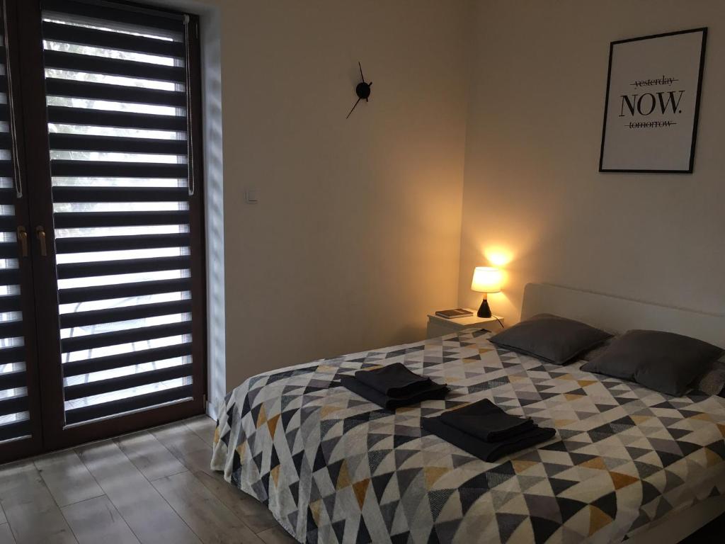 雷布尼克Studio Fibra Macchiato的一间卧室配有一张带 ⁇ 子毯子的床