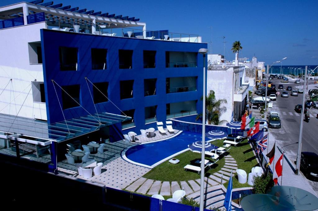 新福卡科特迪斯特酒店的蓝色的建筑,设有游泳池,毗邻街道