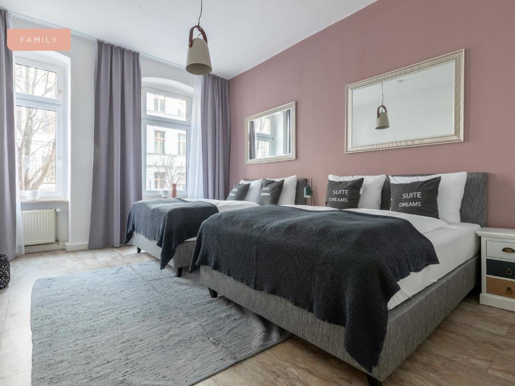 柏林Apartment Berlin Lottumstraße的卧室设有两张粉红色的床铺。