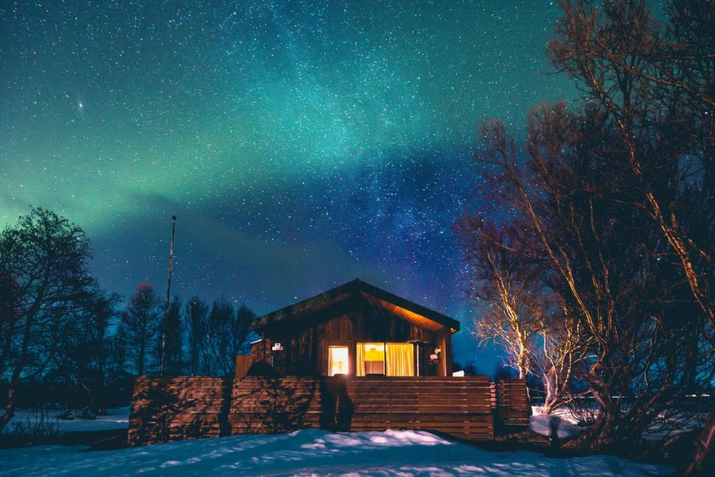 SkogarCabin in the lava. Near Húsavík的星空下雪中的一个小屋