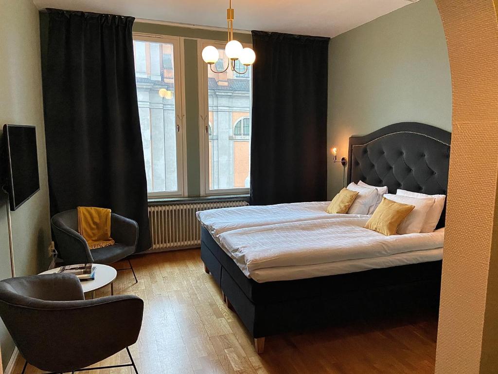 卡尔斯克鲁纳第一斯达特酒店的卧室配有床、椅子和窗户。