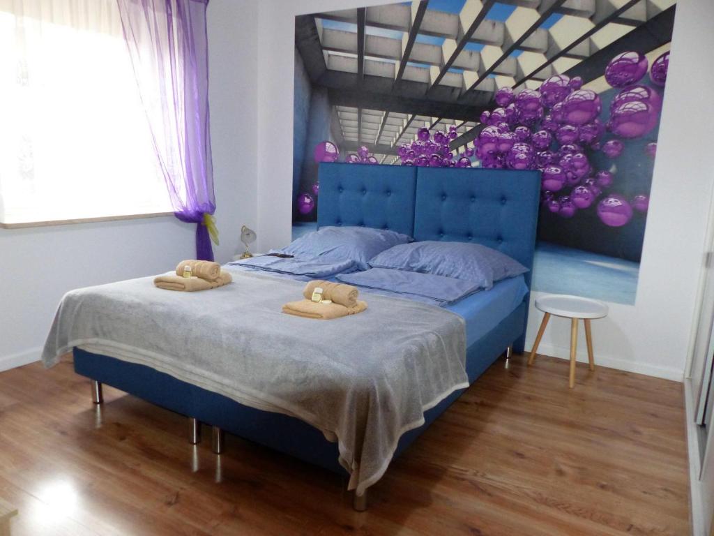 比托姆Apartament Kraszewskiego的一间卧室配有蓝色的床和2条毛巾