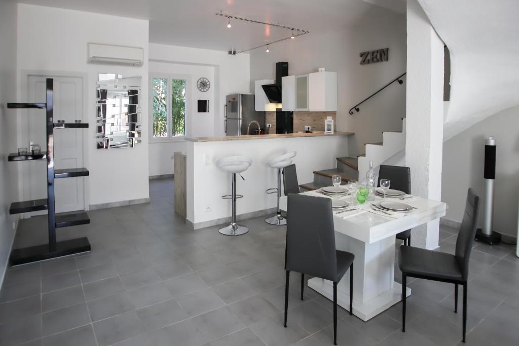 埃瑞兹Maison tendance avec jardin, centre village, Alpilles, familles的厨房以及带白色桌椅的用餐室。