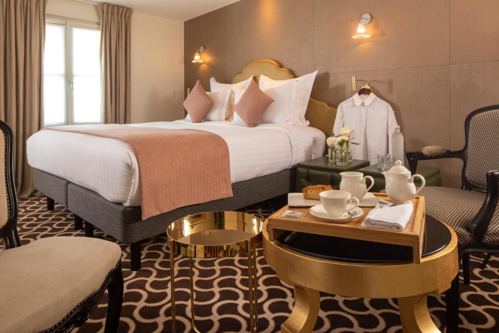 巴黎普拉帝酒店的酒店客房带一张床、一张桌子和椅子
