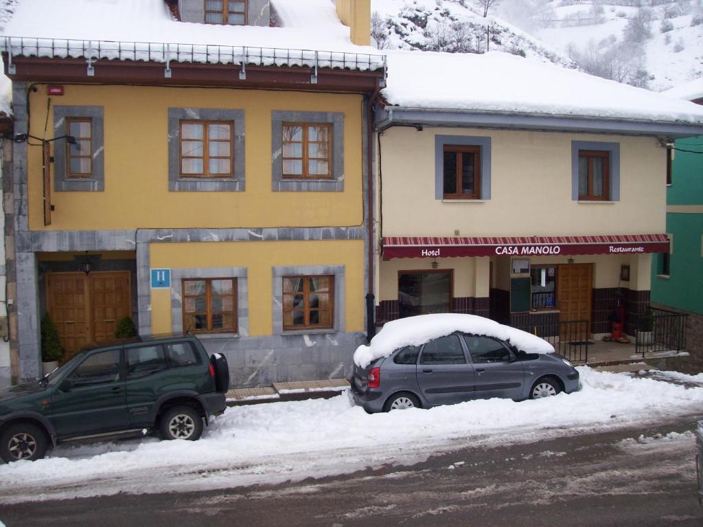 帕拉莫卡萨马诺洛酒店餐厅的两辆汽车停在雪屋前