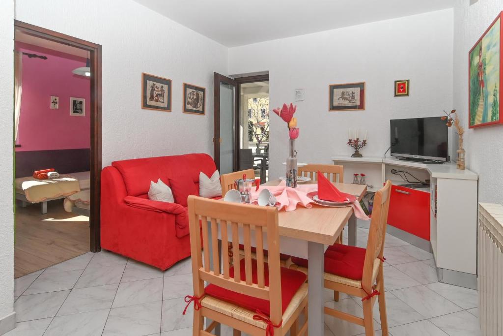 木洛希尼苏西卡公寓酒店的客厅配有桌子和红色沙发