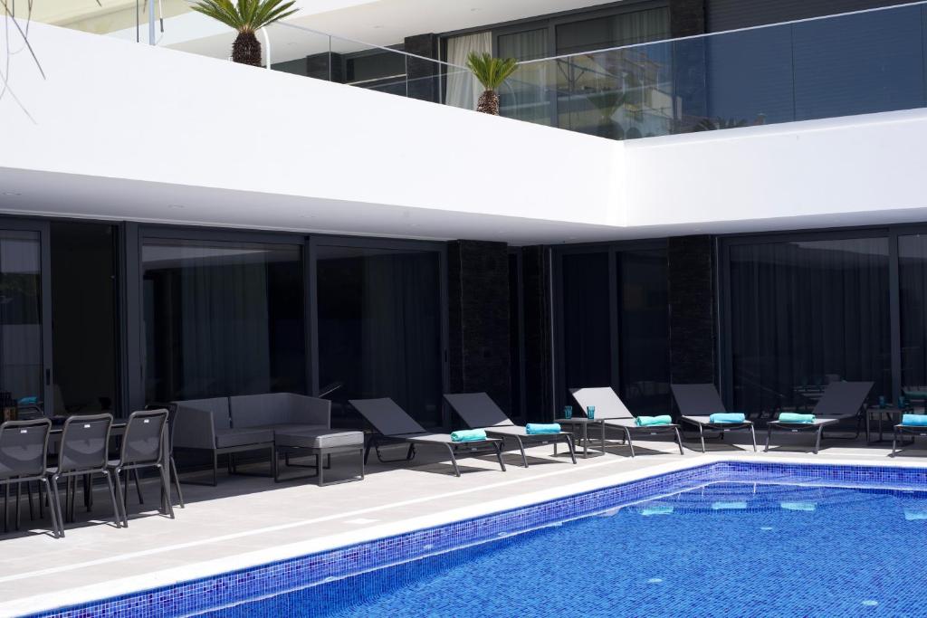 波尔蒂芒Luxury Villa Aleana的一座带游泳池和椅子的建筑和一座建筑