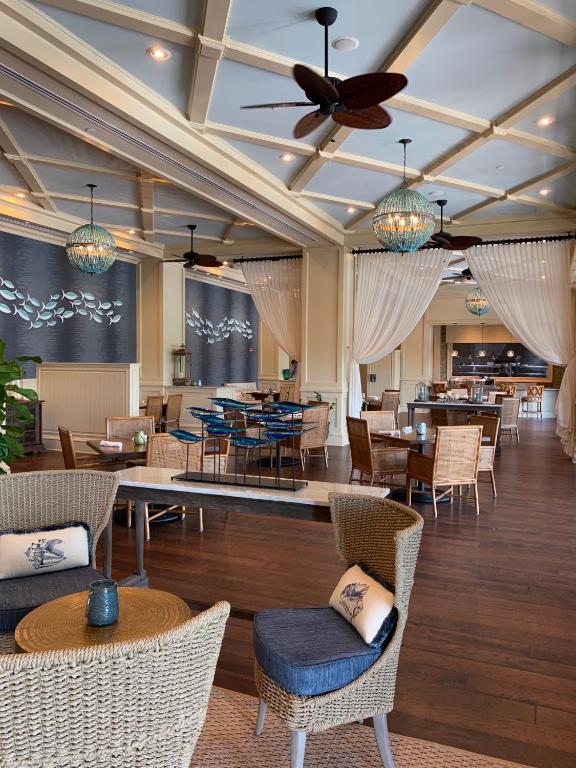 德斯坦Henderson Beach Resort的有桌椅和天花板的餐厅