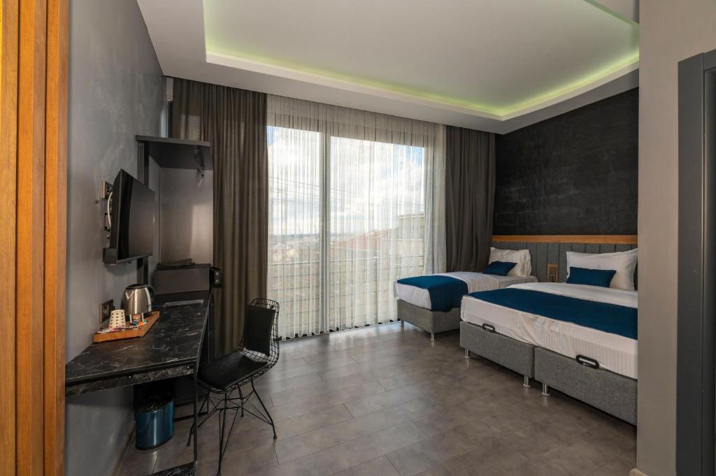 ArnavutköyMelanj Airport Hotel的酒店客房设有两张床和电视。