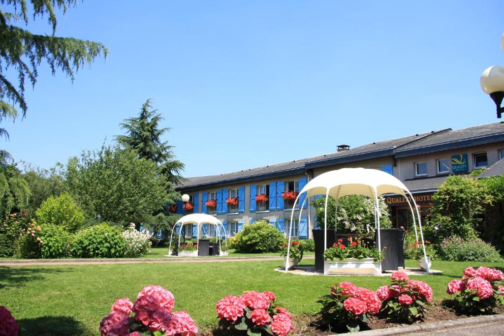 圣马丁杜维维La Berteliere, The Originals Relais (Qualys-Hotel)的花园设有两个凉亭和鲜花