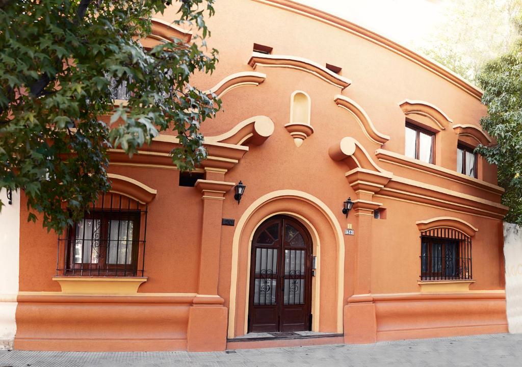 萨尔塔Donna Alda Casa的橙色的建筑,设有两扇窗户和一扇门