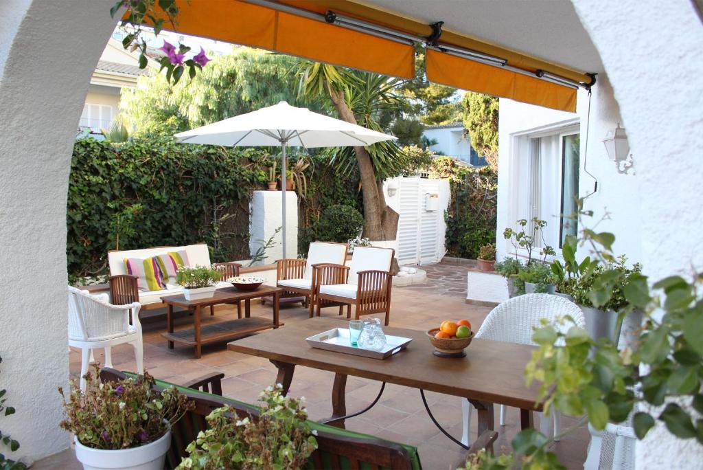 锡切斯锡切斯度假屋的庭院配有桌椅和遮阳伞。