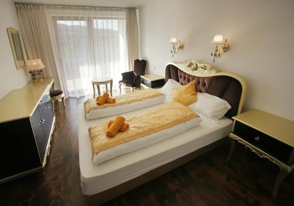 Domaša DobráGarden Hotel Domaša的一间卧室配有两张带棕色棉被的床