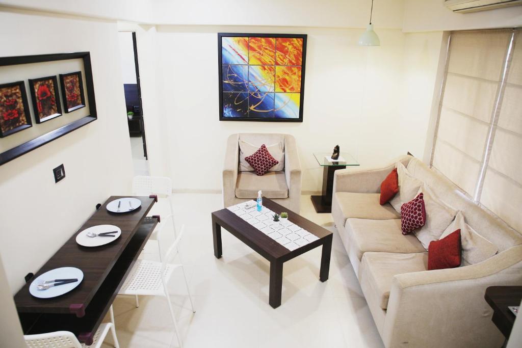 孟买Lite Stays - Vile Parle East的客厅配有沙发和桌子
