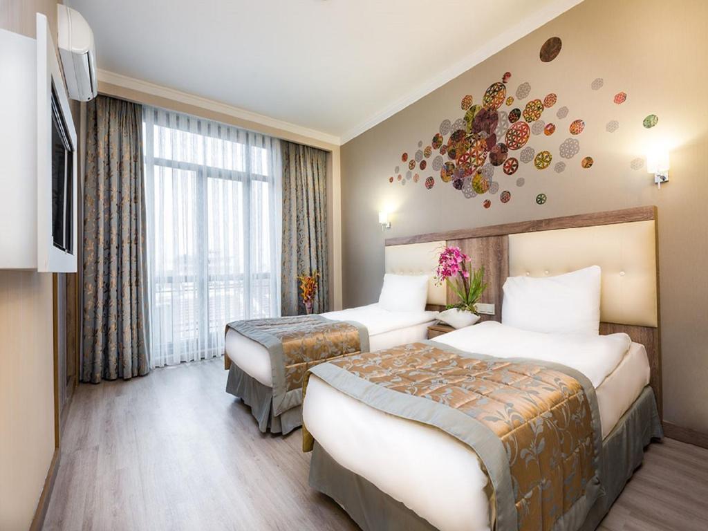 伊斯坦布尔康纳尔法提赫酒店的一间酒店客房,设有两张床和电视