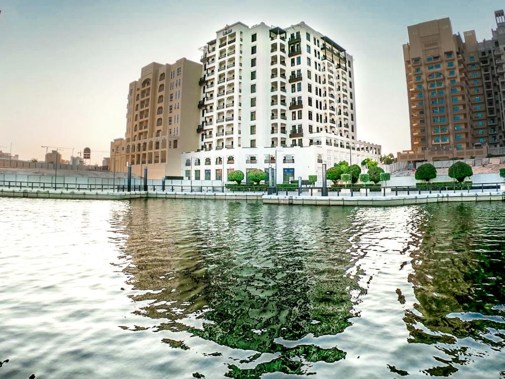 迪拜Suha Creek Hotel Apartment, Waterfront Jaddaf, Dubai的一大片水边的大建筑
