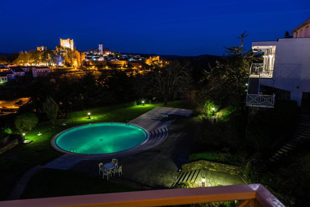 布拉干萨布拉干萨望厦宾馆 - 圣巴托洛梅乌的一个晚上的游泳池,以城市为背景