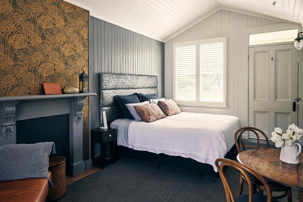 克莱德Dunstan Times的一间卧室配有一张床、一张桌子和一个窗户。