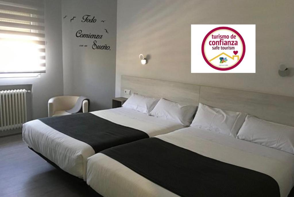 萨拉曼卡Hostal I Dream Salamanca的卧室配有两张床,墙上有标志