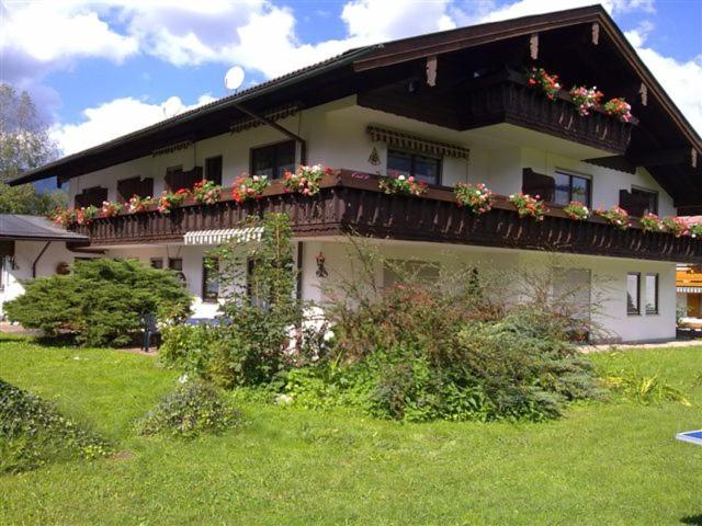柯尼希斯湖畔舍瑙Alpenpension Bergidyll的一座房子,阳台上种着鲜花