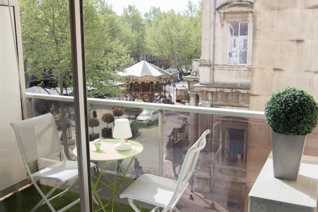 阿维尼翁Appartement Moustier - Welkeys的阳台配有白色的椅子和桌子,大楼