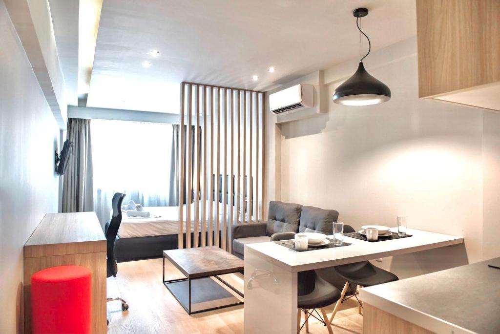 塞萨洛尼基#Aura Studios & Suites V9-10的厨房以及带桌椅的起居室。