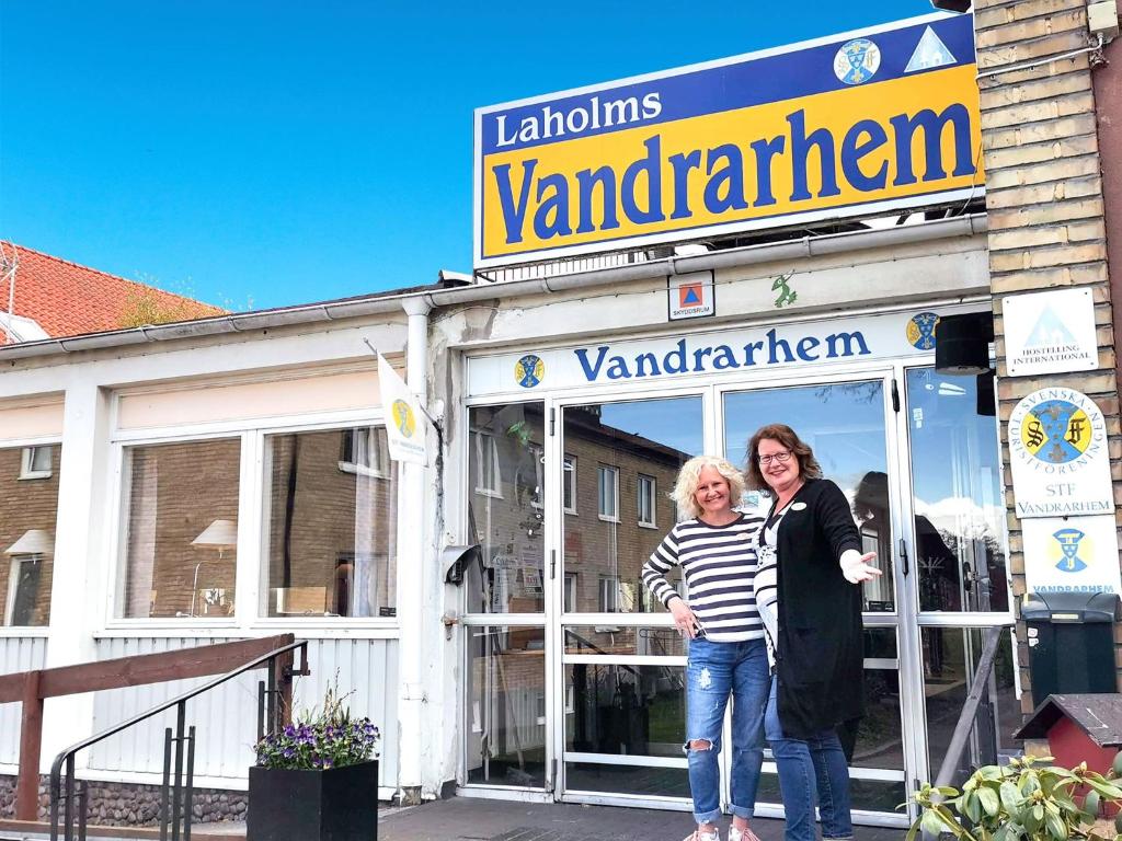 拉霍尔姆Laholms Vandrarhem的两个女人站在商店前