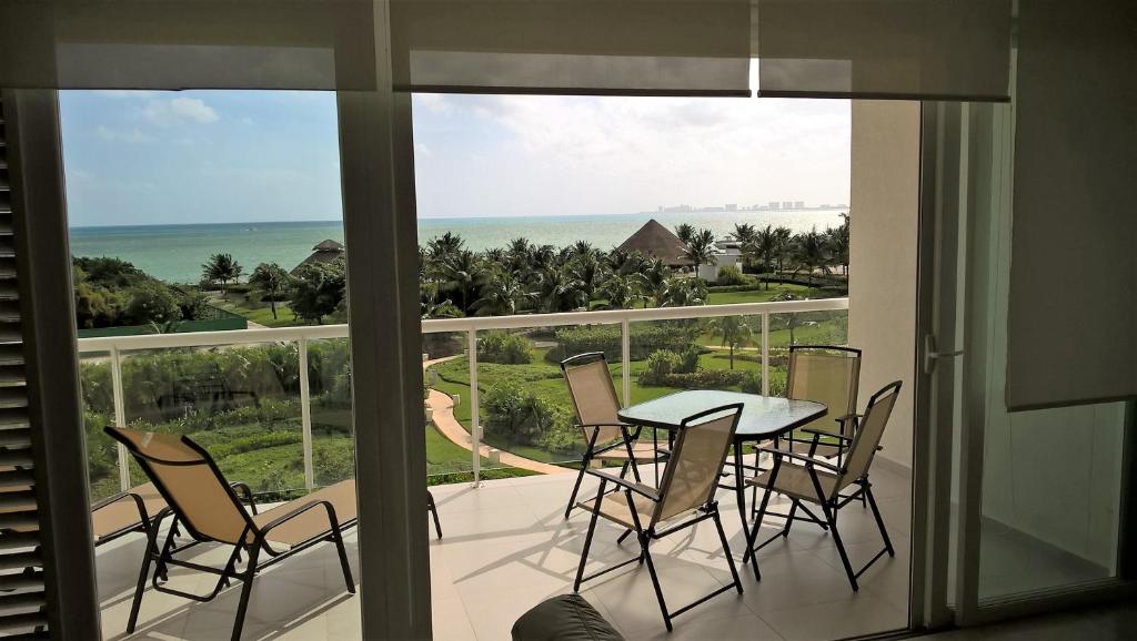 坎昆Swim the Caribbean & Work with a View的阳台配有桌椅,享有海景。