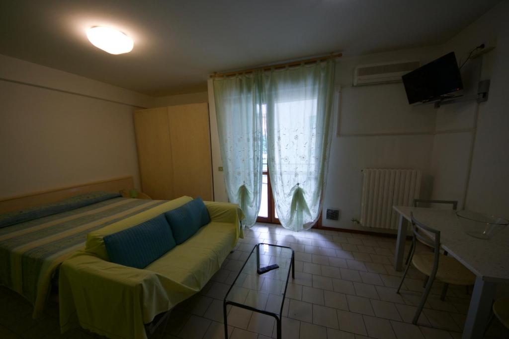 帕尔马帕米贾尼诺公寓的客房设有床、沙发和窗户。