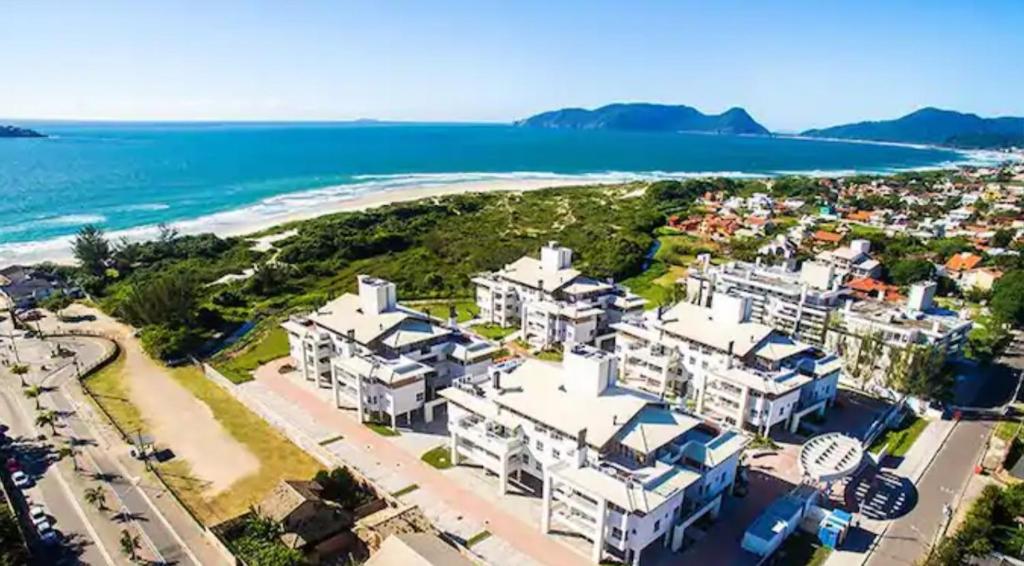 弗洛里亚诺波利斯Apartamento na Praia do Campeche的享有海滩的空中景致,设有白色房屋