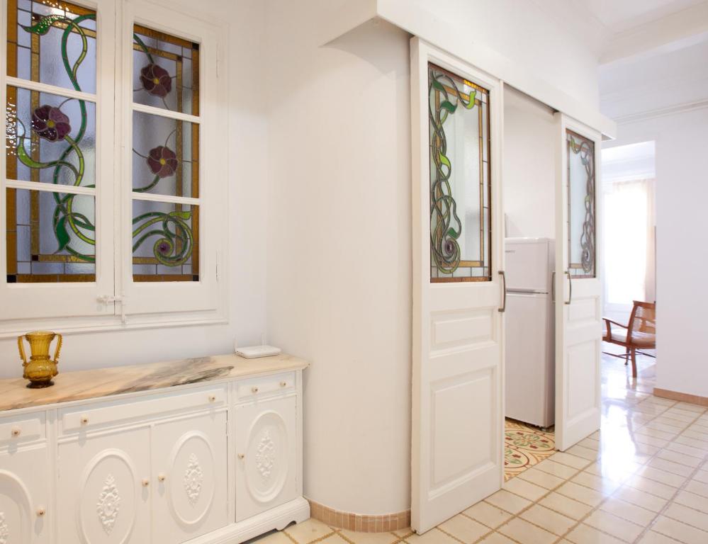 巴塞罗那穆塔纳尔酒店的白色的房间,设有白色的门和彩色玻璃窗