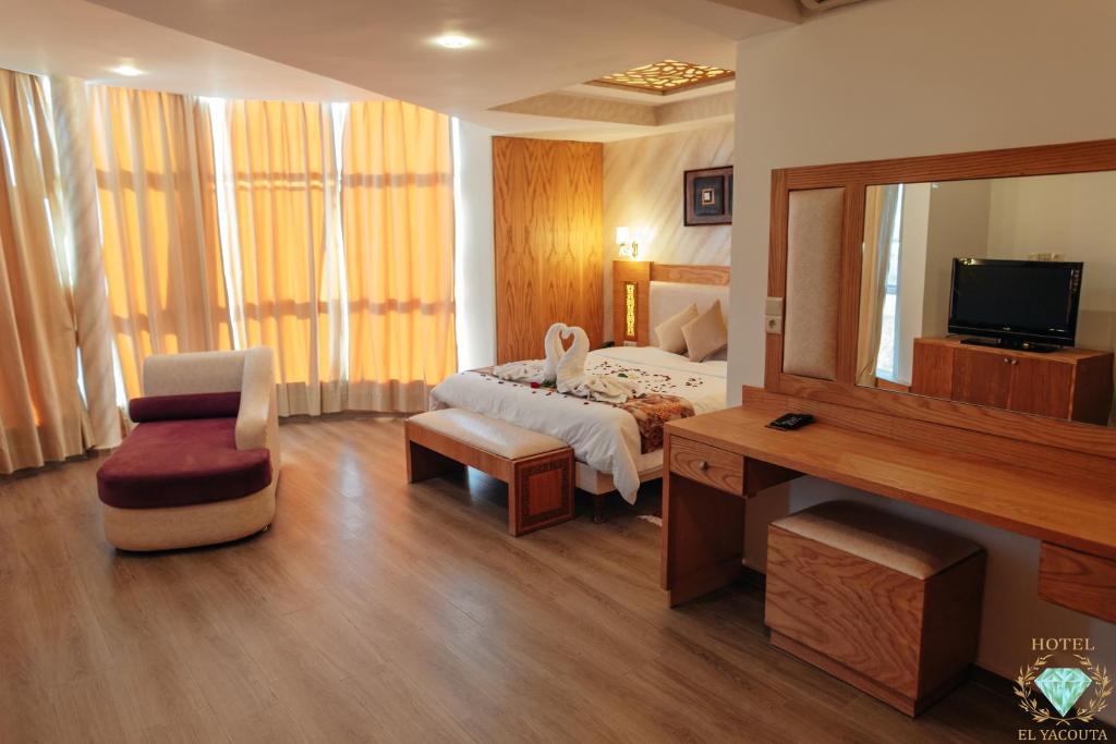 得土安伊尔雅库塔酒店的一间卧室配有一张床、一张书桌和一面镜子