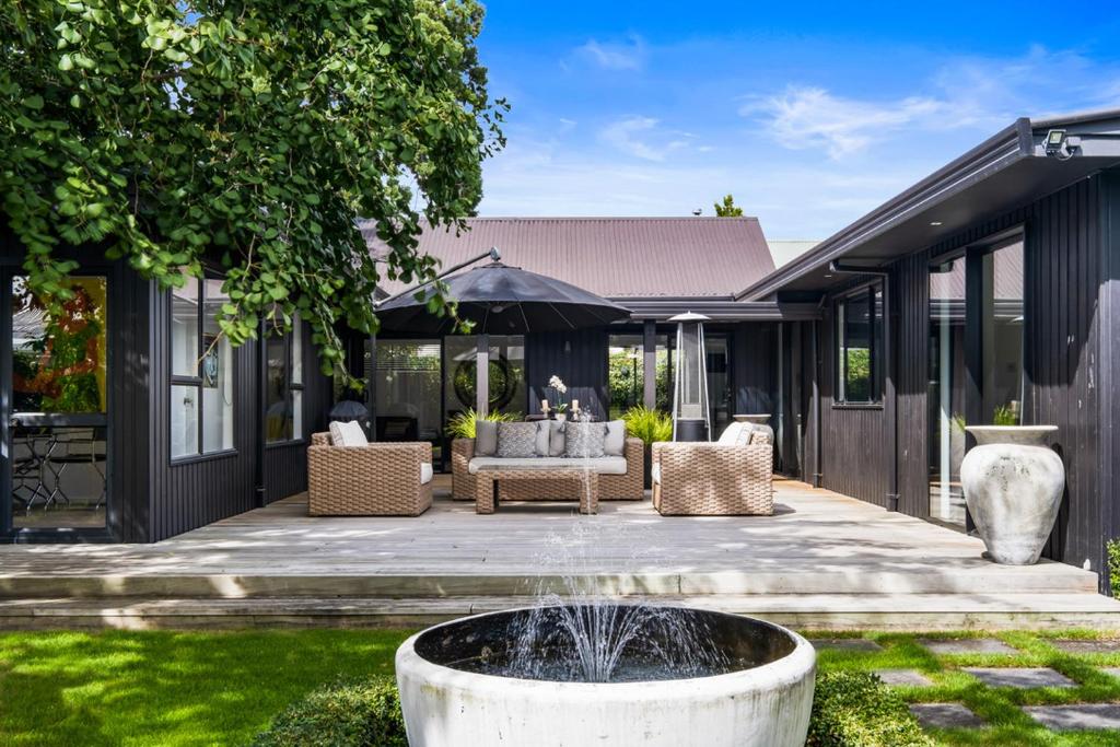 布伦海姆Black Luxury Lodge的房屋前方带喷泉的庭院