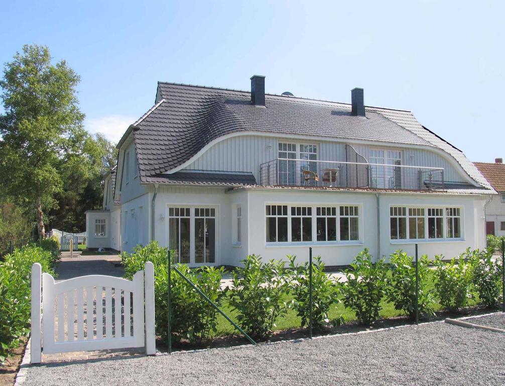 普雷罗Holiday home in Prerow (Ostseebad) 2650的白色房子前面的白色长凳
