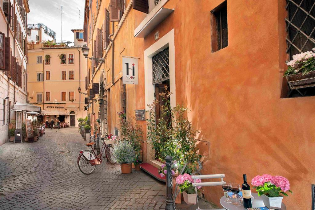 罗马罗马你好套房酒店的楼边的一条种植植物的小巷