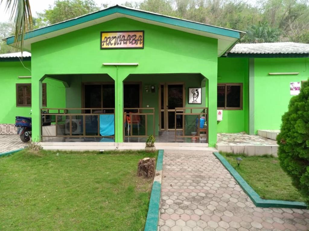 Oko SomboPANAASA GUEST HOUSE的前面有标志的绿色建筑