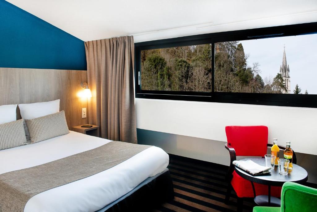卢尔德全景酒店的酒店客房设有床和窗户。