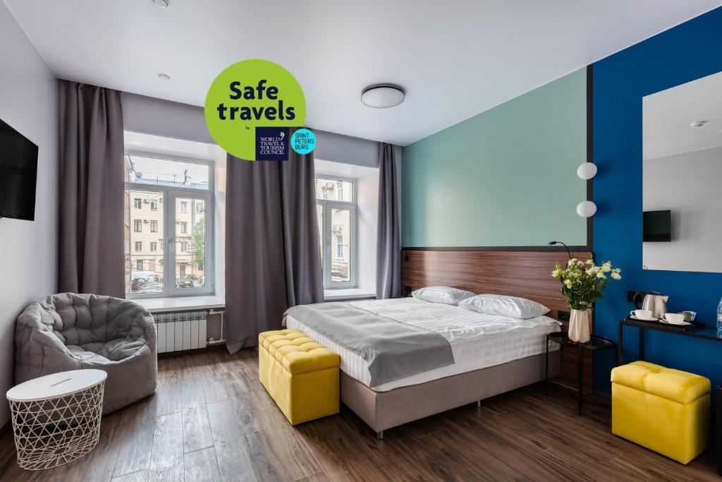 圣彼得堡Renome Hotel的配有一张床和一把椅子的酒店客房