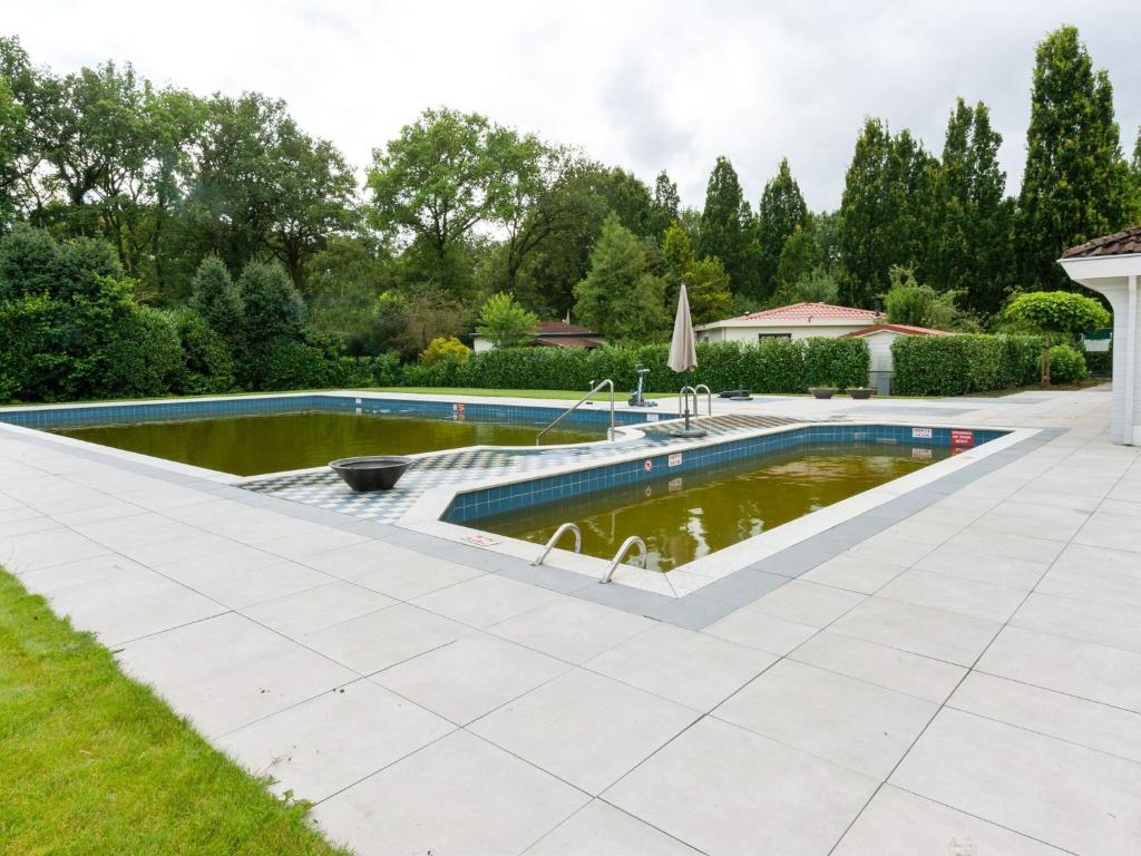 Stegeren汇斯耶阿提度假屋的庭院内的游泳池,庭院内有庭院和草地