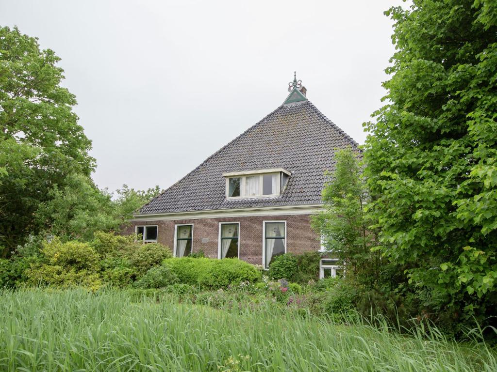 MolkwerumModern Farmhouse in Molkwerum near the Lake的一个带 ⁇ 屋顶和花园的房子