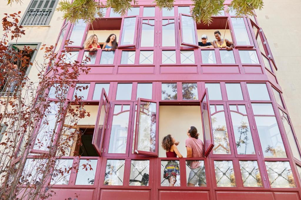 马略卡岛帕尔马The Boc Hostels - Palma的一群人从粉红色的建筑中看出来