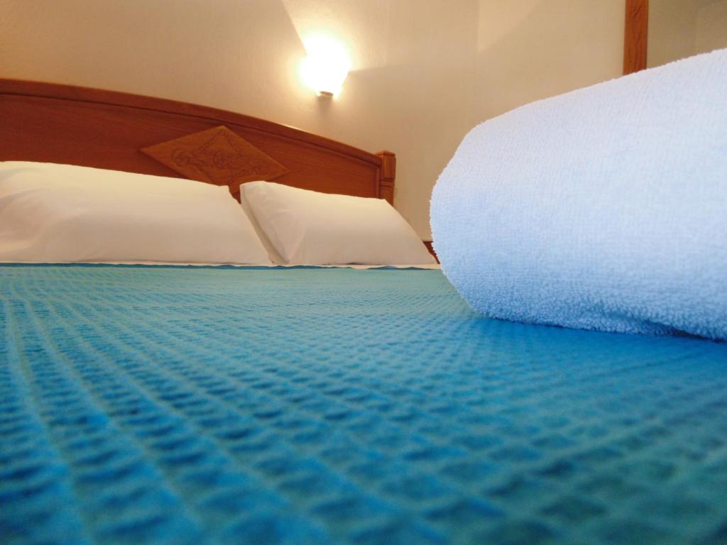 帕蒂迪里奥梅林尼公寓的一间卧室配有一张带白色枕头和蓝色床单的床
