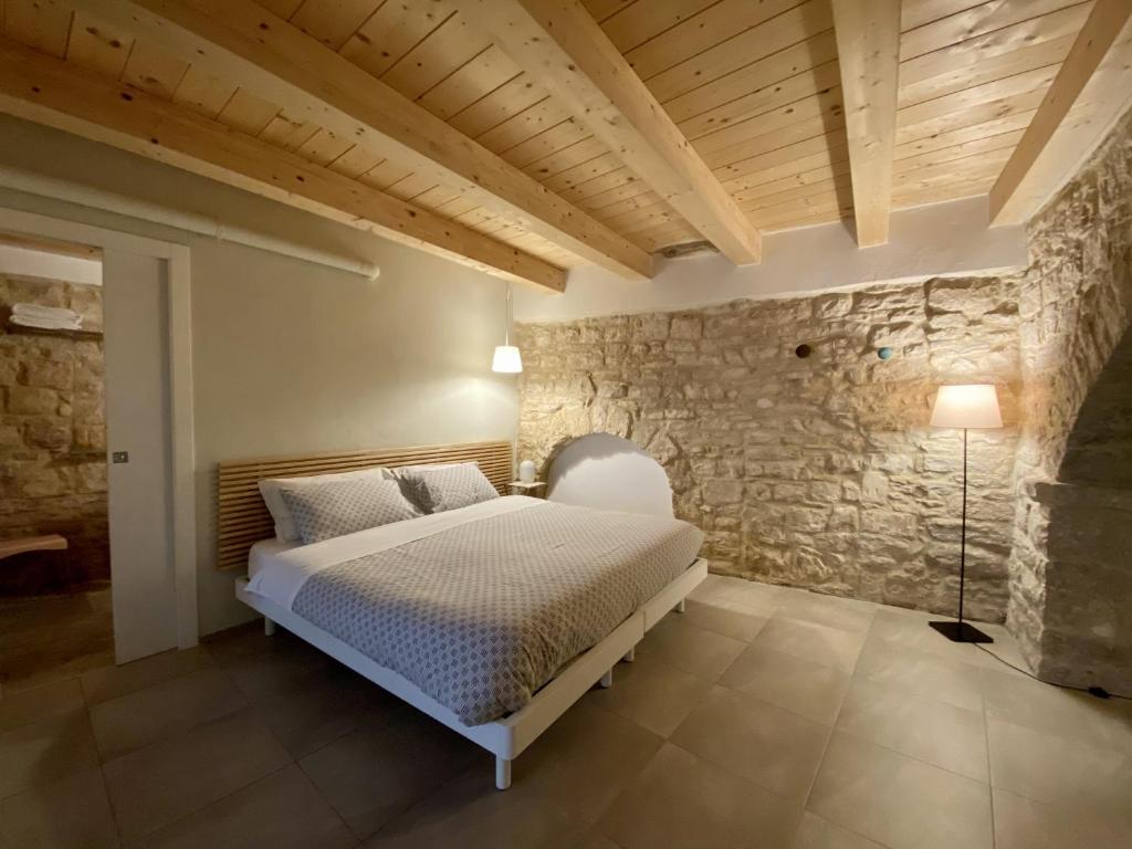阿夸维瓦德莱丰蒂Albertario的一间卧室设有一张床和石墙